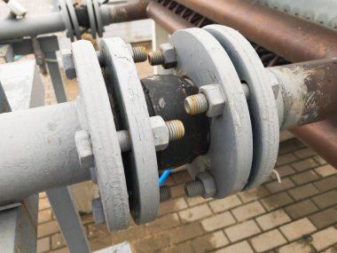 Endüstriyel üretim hattında çatlaklar olan eski gri boyalı kauçuk genişletme eklentisi.