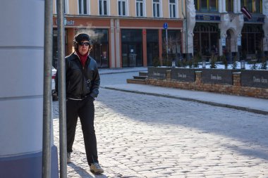 01.03.2018. Riga, Letonya. Şehirde sokakta yürüyen bir adam kulaklıklarla,.