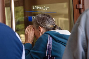 RIGA, LATVIA. 16th August, 2019. Seniors are looking into the window and trying to open doors at PNB Bank (formerly known as Norvik Bank). PNB Bank shut down after European Central Bank (ECB) announcment. clipart
