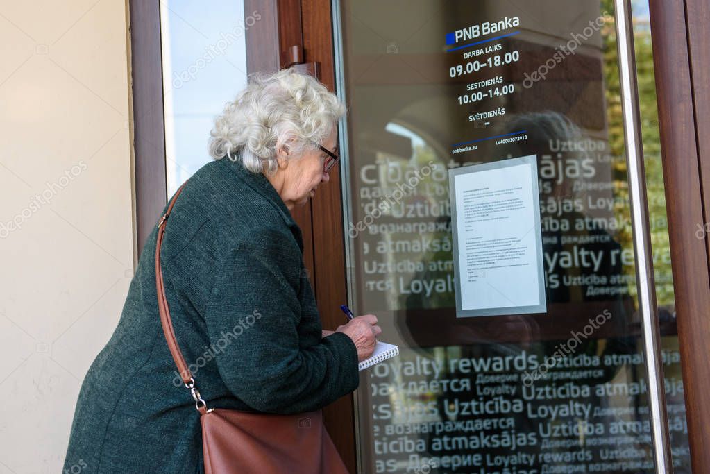 RIGA, LATVIA. 16th August, 2019. Seniors are looking into the window and trying to open doors at PNB Bank (formerly known as Norvik Bank). PNB Bank shut down after European Central Bank (ECB) announcment.