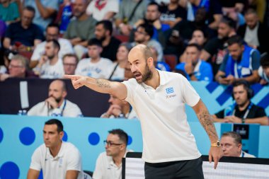 RIGA, LATVIA. 7 Eylül 2025. FIBA EUROBASKET 2025 basketbol karşılaşmasında Yunanistan teknik direktörü Vasileios Spanoulis (R), Yunanistan milli takımı ile İsrail milli takımı arasında oynanan karşılaşmada.