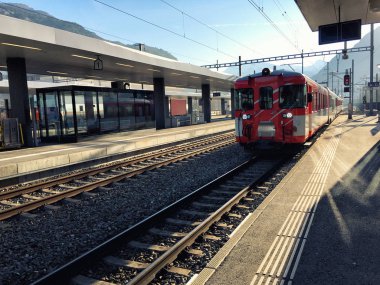 Red swiss train on platform, Switzerland  clipart
