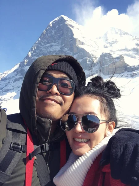 Young couple taking a selfie on snow mountain in Switzerland