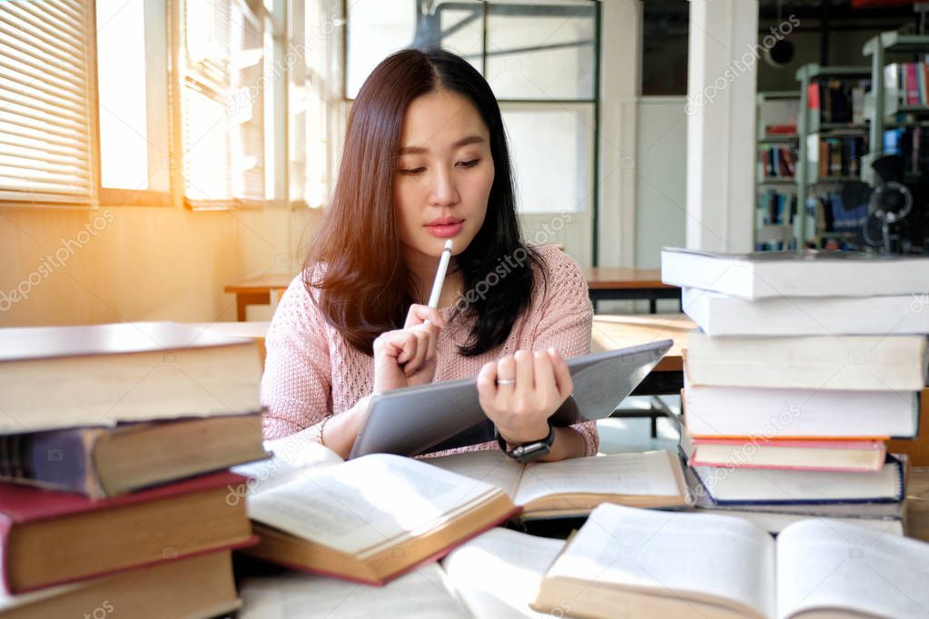 Young woman using tablet in a library