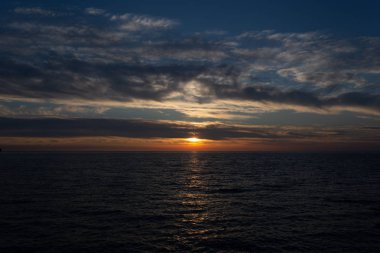 Gargano yarımadasında Peschici kasabası yakınlarında Adriyatik denizi üzerinde gün batımında bulutlar ile güzel gökyüzü, İtalya