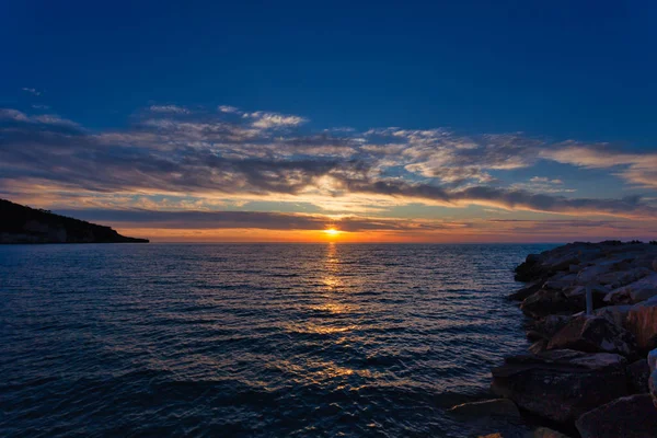 Gargano yarımadasında Peschici kasabası yakınlarında Adriyatik denizi üzerinde gün batımında bulutlar ile güzel gökyüzü, İtalya