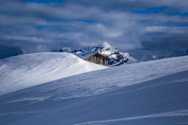 Alplerde karla kaplı ahşap kulübe
