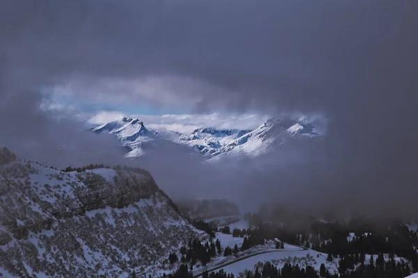 Aussicht zwischen Wolken auf sonnenbeschienene Berge — Stockfoto