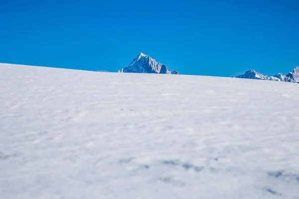 Śnieżne równiny i góry, słoneczny dzień, miejsce na tekst — Zdjęcie stockowe