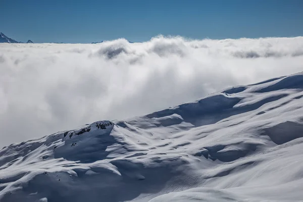 Panorama delle montagne che sorgono dalle nuvole — Foto Stock