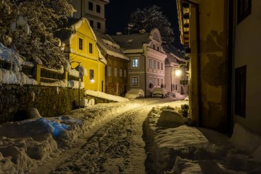 Cesky Krumlov 'un kış manzarası, kalenin altında karla kaplı çatıları olan resimli evler. Dar sokaklar ve Vltava nehri. Avrupa 'da seyahat ve tatil. Noel zamanı. UNESCO Dünya Mirası. Çek Cumhuriyeti