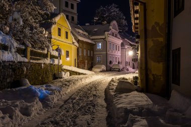 Cesky Krumlov 'un kış manzarası, kalenin altında karla kaplı çatıları olan resimli evler. Dar sokaklar ve Vltava nehri. Avrupa 'da seyahat ve tatil. Noel zamanı. UNESCO Dünya Mirası. Çek Cumhuriyeti
