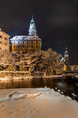 Cesky Krumlov 'un kış manzarası, kalenin altında karla kaplı çatıları olan resimli evler. Dar sokaklar ve Vltava nehri. Avrupa 'da seyahat ve tatil. Noel zamanı. UNESCO Dünya Mirası. Çek Cumhuriyeti