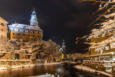 Cesky Krumlov 'un kış manzarası, kalenin altında karla kaplı çatıları olan resimli evler. Dar sokaklar ve Vltava nehri. Avrupa 'da seyahat ve tatil. Noel zamanı. UNESCO Dünya Mirası. Çek Cumhuriyeti