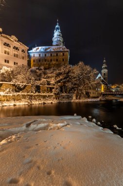 Cesky Krumlov 'un kış manzarası, kalenin altında karla kaplı çatıları olan resimli evler. Dar sokaklar ve Vltava nehri. Avrupa 'da seyahat ve tatil. Noel zamanı. UNESCO Dünya Mirası. Çek Cumhuriyeti