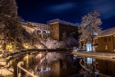 Cesky Krumlov 'un kış manzarası, kalenin altında karla kaplı çatıları olan resimli evler. Dar sokaklar ve Vltava nehri. Avrupa 'da seyahat ve tatil. Noel zamanı. UNESCO Dünya Mirası. Çek Cumhuriyeti