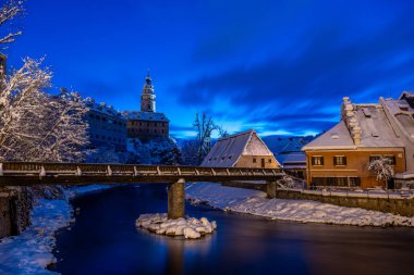 Cesky Krumlov 'un kış manzarası, kalenin altında karla kaplı çatıları olan resimli evler. Dar sokaklar ve Vltava nehri. Avrupa 'da seyahat ve tatil. Noel zamanı. UNESCO Dünya Mirası. Çek Cumhuriyeti