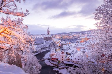 Cesky Krumlov 'un kış manzarası, kalenin altında karla kaplı çatıları olan resimli evler. Dar sokaklar ve Vltava nehri. Avrupa 'da seyahat ve tatil. Noel zamanı. UNESCO Dünya Mirası. Çek Cumhuriyeti