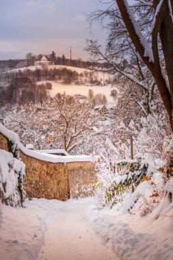 Cesky Krumlov 'un kış manzarası, kalenin altında karla kaplı çatıları olan resimli evler. Dar sokaklar ve Vltava nehri. Avrupa 'da seyahat ve tatil. Noel zamanı. UNESCO Dünya Mirası. Çek Cumhuriyeti