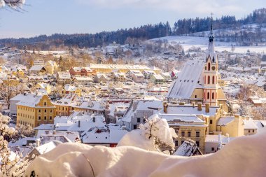 Cesky Krumlov 'un kış manzarası, kalenin altında karla kaplı çatıları olan resimli evler. Dar sokaklar ve Vltava nehri. Avrupa 'da seyahat ve tatil. Noel zamanı. UNESCO Dünya Mirası. Çek Cumhuriyeti