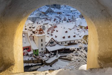 Cesky Krumlov 'un kış manzarası, kalenin altında karla kaplı çatıları olan resimli evler. Dar sokaklar ve Vltava nehri. Avrupa 'da seyahat ve tatil. Noel zamanı. UNESCO Dünya Mirası. Çek Cumhuriyeti