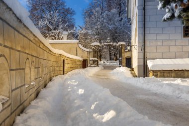 Cesky Krumlov 'un kış manzarası, kalenin altında karla kaplı çatıları olan resimli evler. Dar sokaklar ve Vltava nehri. Avrupa 'da seyahat ve tatil. Noel zamanı. UNESCO Dünya Mirası. Çek Cumhuriyeti