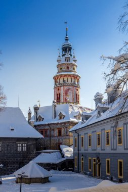 Cesky Krumlov 'un kış manzarası, kalenin altında karla kaplı çatıları olan resimli evler. Dar sokaklar ve Vltava nehri. Avrupa 'da seyahat ve tatil. Noel zamanı. UNESCO Dünya Mirası. Çek Cumhuriyeti