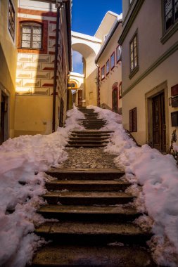 Cesky Krumlov 'un kış manzarası, kalenin altında karla kaplı çatıları olan resimli evler. Dar sokaklar ve Vltava nehri. Avrupa 'da seyahat ve tatil. Noel zamanı. UNESCO Dünya Mirası. Çek Cumhuriyeti