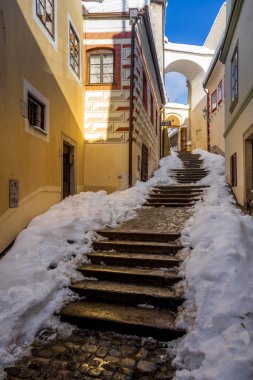 Cesky Krumlov 'un kış manzarası, kalenin altında karla kaplı çatıları olan resimli evler. Dar sokaklar ve Vltava nehri. Avrupa 'da seyahat ve tatil. Noel zamanı. UNESCO Dünya Mirası. Çek Cumhuriyeti
