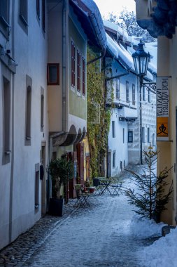 Cesky Krumlov 'un kış manzarası, kalenin altında karla kaplı çatıları olan resimli evler. Dar sokaklar ve Vltava nehri. Avrupa 'da seyahat ve tatil. Noel zamanı. UNESCO Dünya Mirası. Çek Cumhuriyeti