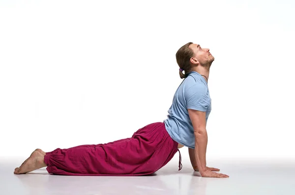 Pratik yoga longhair adam sakallı. Model beyaz arka plan üzerinde izole egzersizleri yapıyor. Bhudjangasana poz. Tam boy