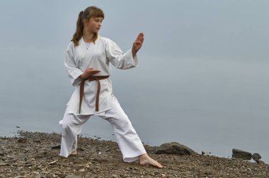 Karate, Japon dövüş sanatları nehir kıyısında pratik Kimono genç kadın. Sisli sabah erken