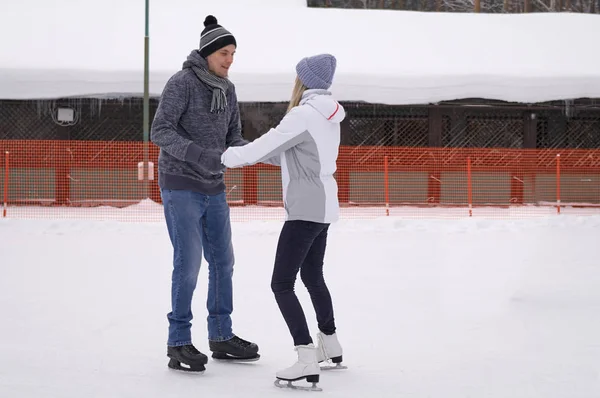 Jong stel schaatsen op een openbare schaatsbaan buiten in th — Stockfoto