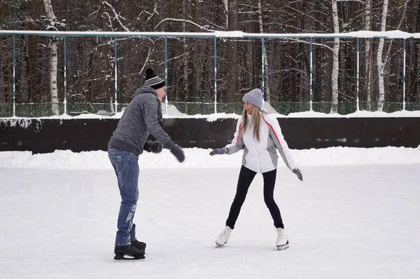 Jeune couple patinant sur une patinoire publique en plein air à th — Photo