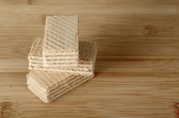 Hafif ahşap kesme tahtasındaki wafer kurabiyelerinin tonlu yakın plan fotoğrafı..