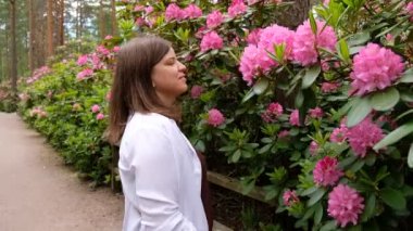 Rhododendrons Parkı 'nda yürüyen bir kadın. Finlandiya 'nın Helsinki şehrinin en popüler ve en güzel yerlerinden biridir..