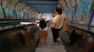 Helsinki, Finlandiya - 21 Haziran 2020: Anne ve kızı metro asansöründe aşağı iniyor.