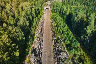 Demiryolu hattının havadan görüntüsü. Tepeler arasındaki demiryolu bir tünele gidiyor..