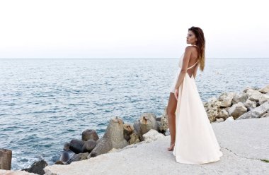 Sevimli kız sahil üzerinde kayalık kayalar poz