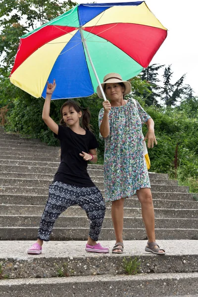 幸せな祖母と孫娘を大きなカラフルな傘 — ストック写真