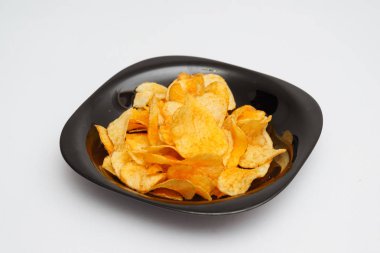 patates cipsi beyaz bez arka plan üzerinde siyah plaka üzerinde avuç