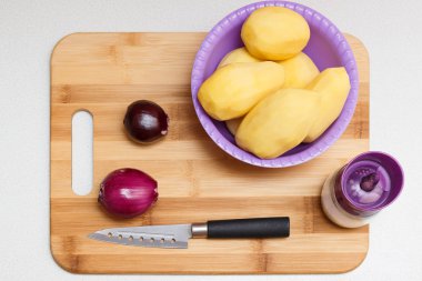 patates, soğan, tuz ve mutfak bıçak üzerinde kurulu üstten görünüm açık mutfak masa arka plan üzerinde kesme