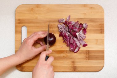 bir bıçak ile kesme tahtası üzerinde kesme soğan.
