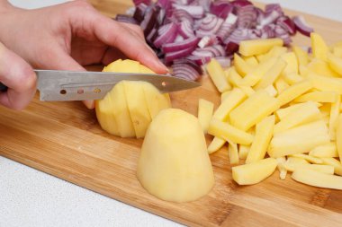 patates ve soğan ile bir bıçak bir bambu kesme tahtası üzerinde yonga