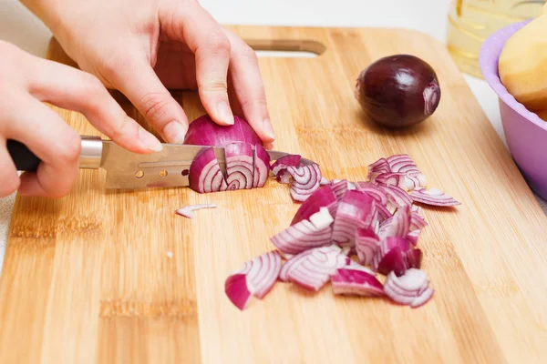 cutting onions on a cutting Board with a knife.