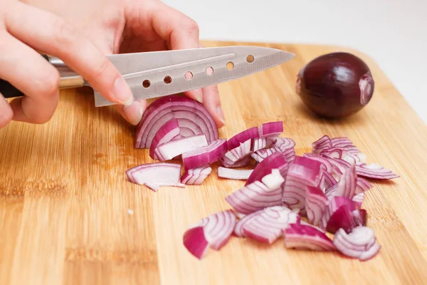 cutting onions on a cutting Board with a knife.