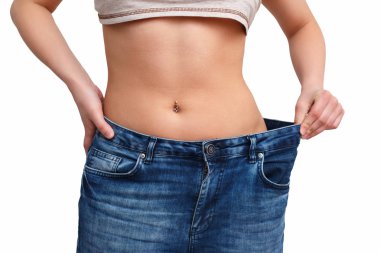 Sıska kız büyük pantolon - kilo kaybı kavramı içinde. Beyaz arka plan üzerinde izole