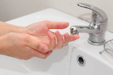 El üzerinde lavabo musluk altında yıkama