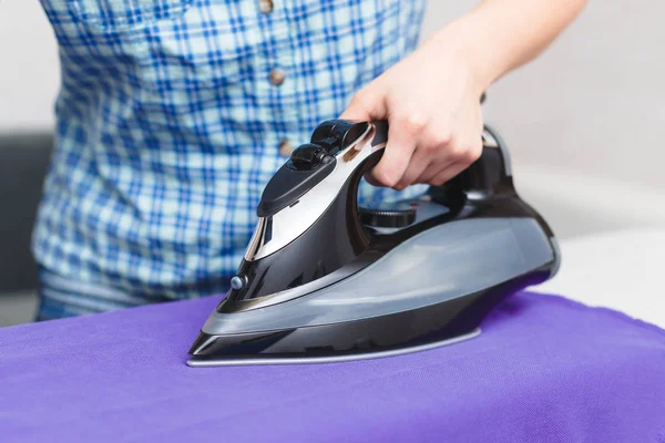 Ironing purple linen iron on Ironing Board