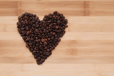 kahve çekirdekleri bir ahşap yüzey üzerinde bir kalp şeklinde ortaya koydu. üstten görünüm